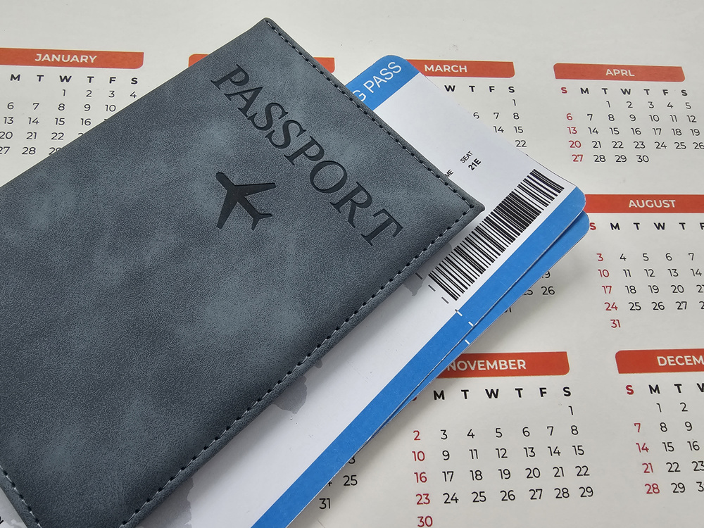 Planning a trip with a passport and travel ticket on a calendar concept