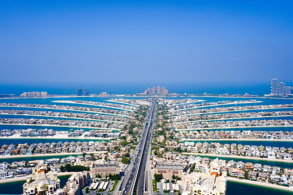 Stunning aerial view of Palm Jumeirah in Dubai, United Arab Emirates, showing the man-made palm-shaped island with luxury villas, resorts, and the iconic Atlantis The Palm hotel in the distance