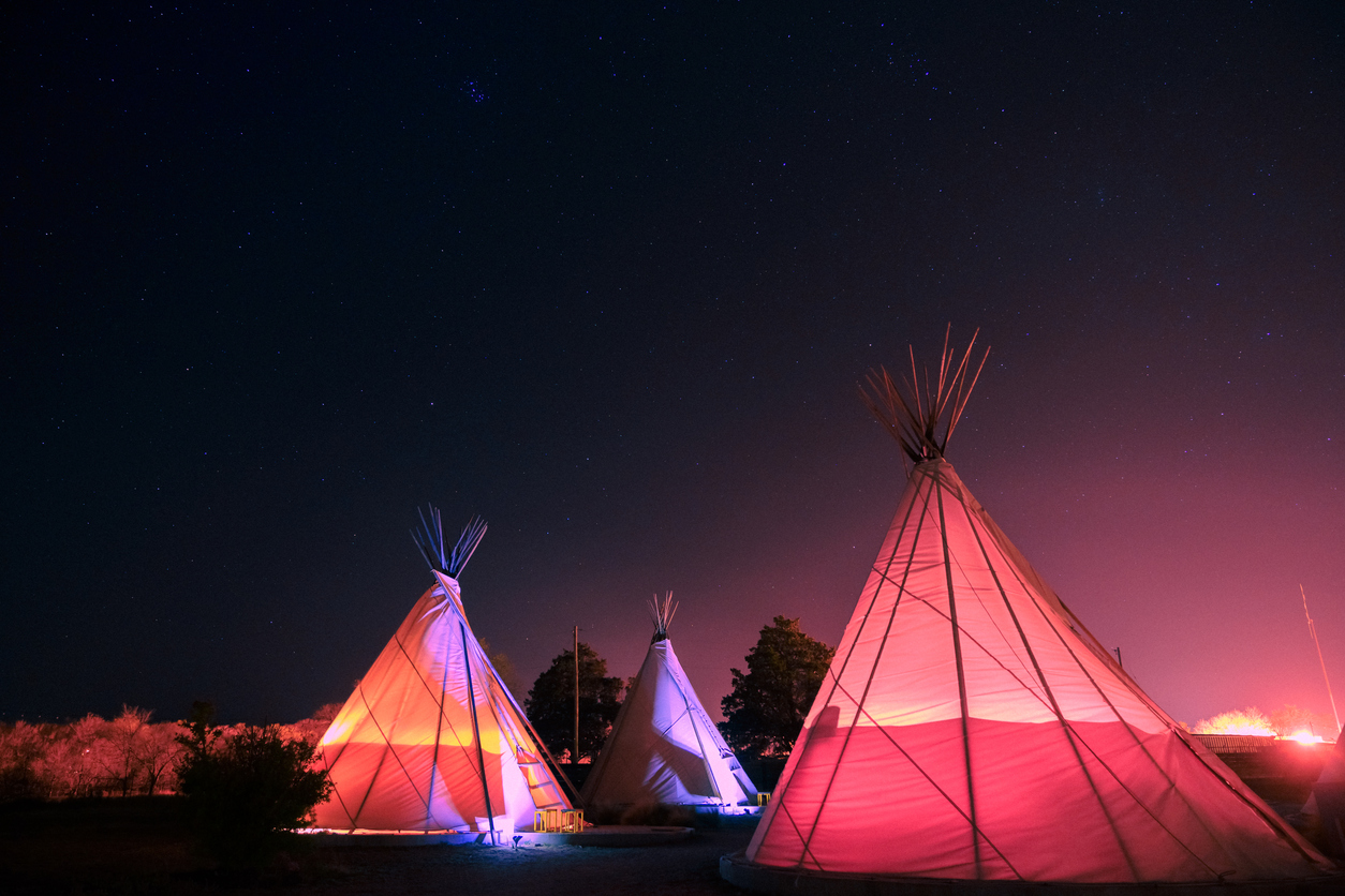 Three teepees glowing at night in the West Texas town of Marfa, Texas