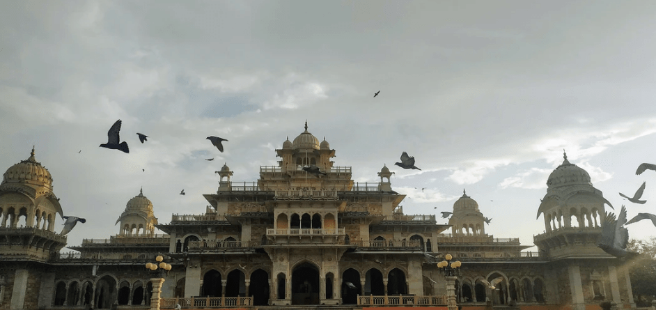 A palace with birds flying around it